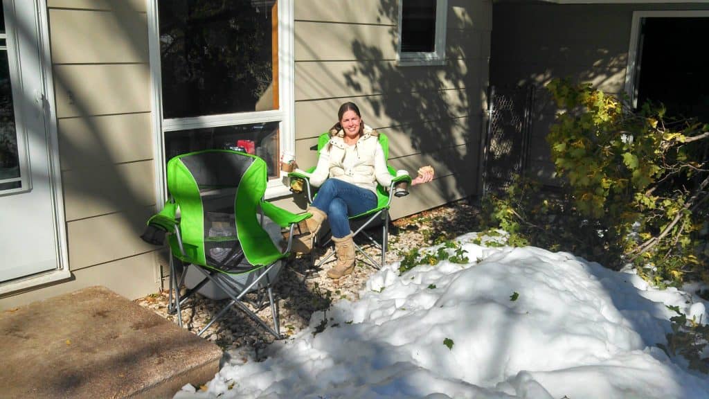 woman sitting in folding camping chair outside in snow