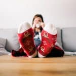 woman sitting on couch with Christmas socks on
