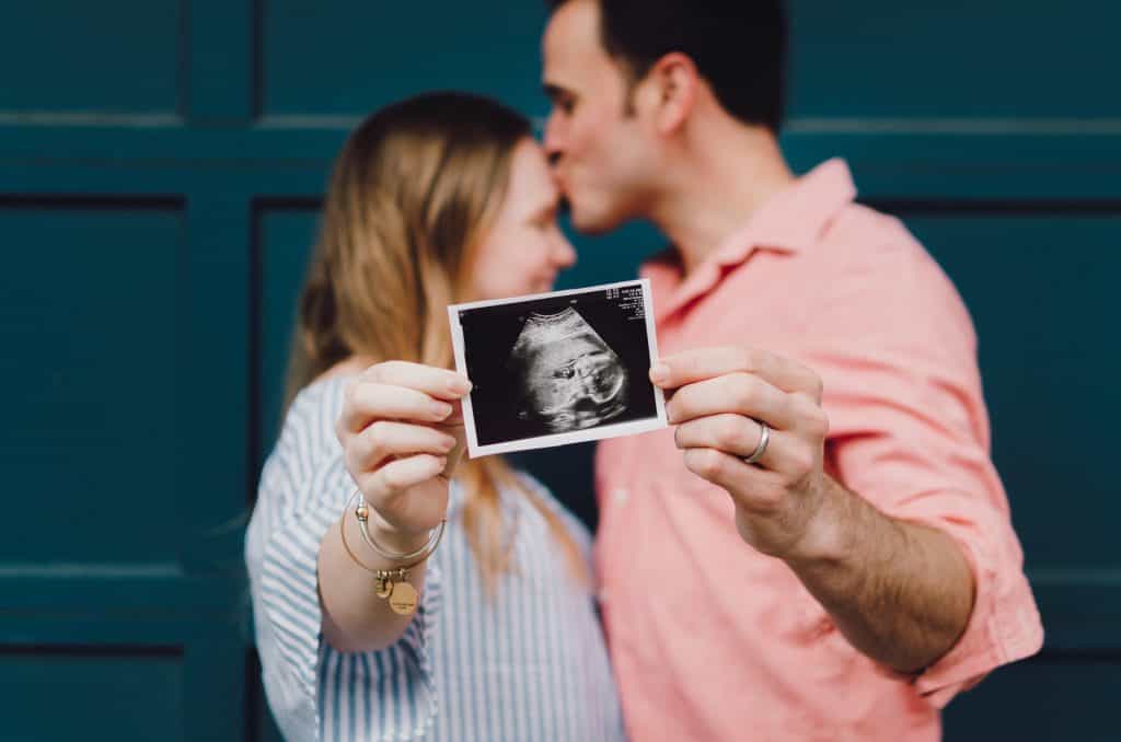 couple holding ultrasound photo together