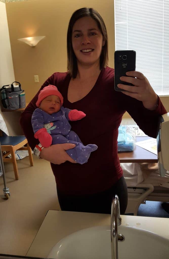 mom taking selfie holding baby in hospital room