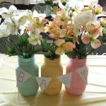 pastel painted mason jars with fake flowers as a baby shower centerpiece