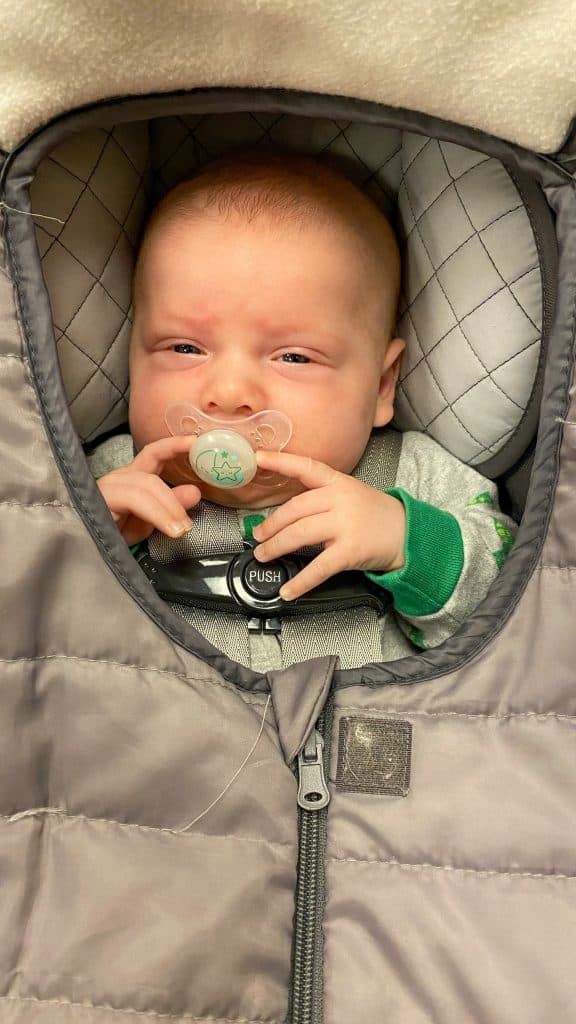 baby in car seat with warm cover