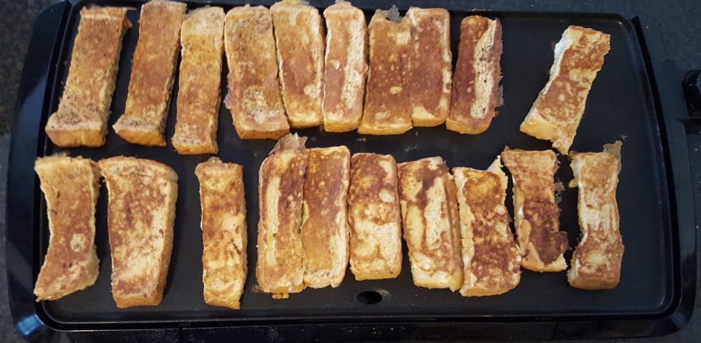 french toast sticks laid out on electric griddle