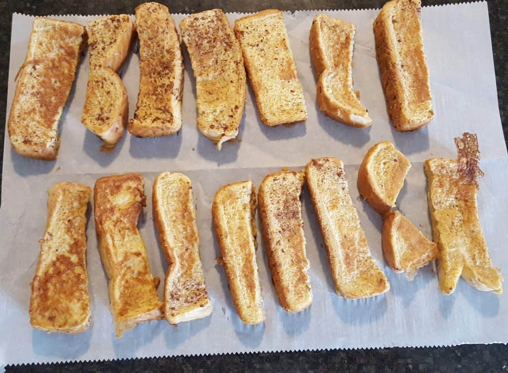 French Toast Sticks laid out on a sheet of parchment paper