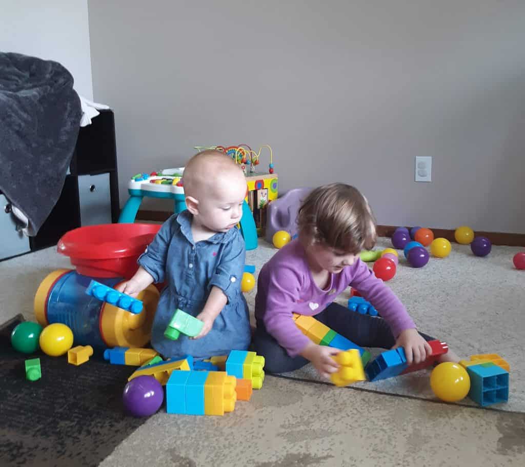 two toddlers playing with blocks