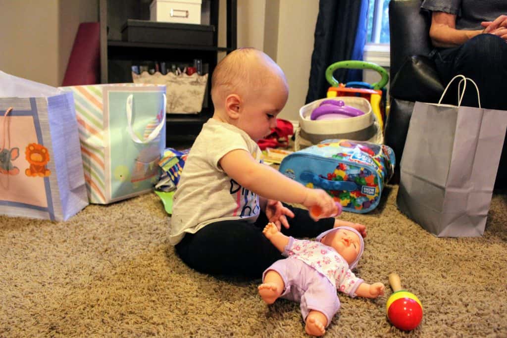 toddler feeding a baby doll a bottle