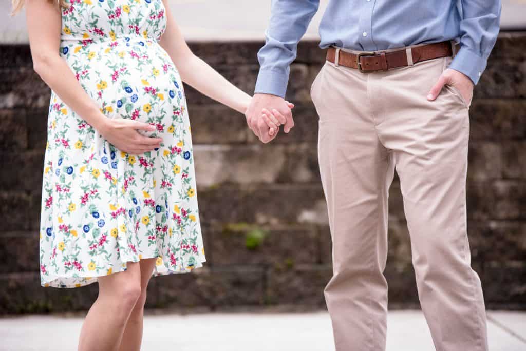 Pregnant woman holding hands with a man