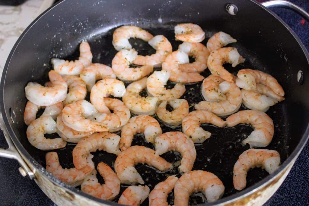 Shrimp sauteing in a frying pan.