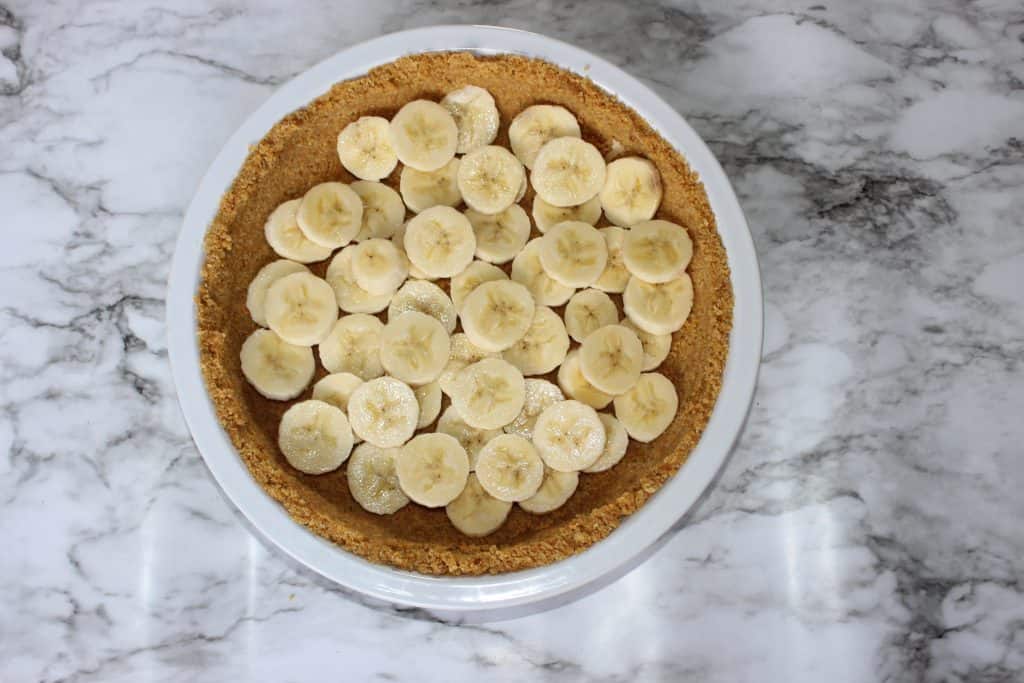 sliced bananas layered over the graham cracker crust