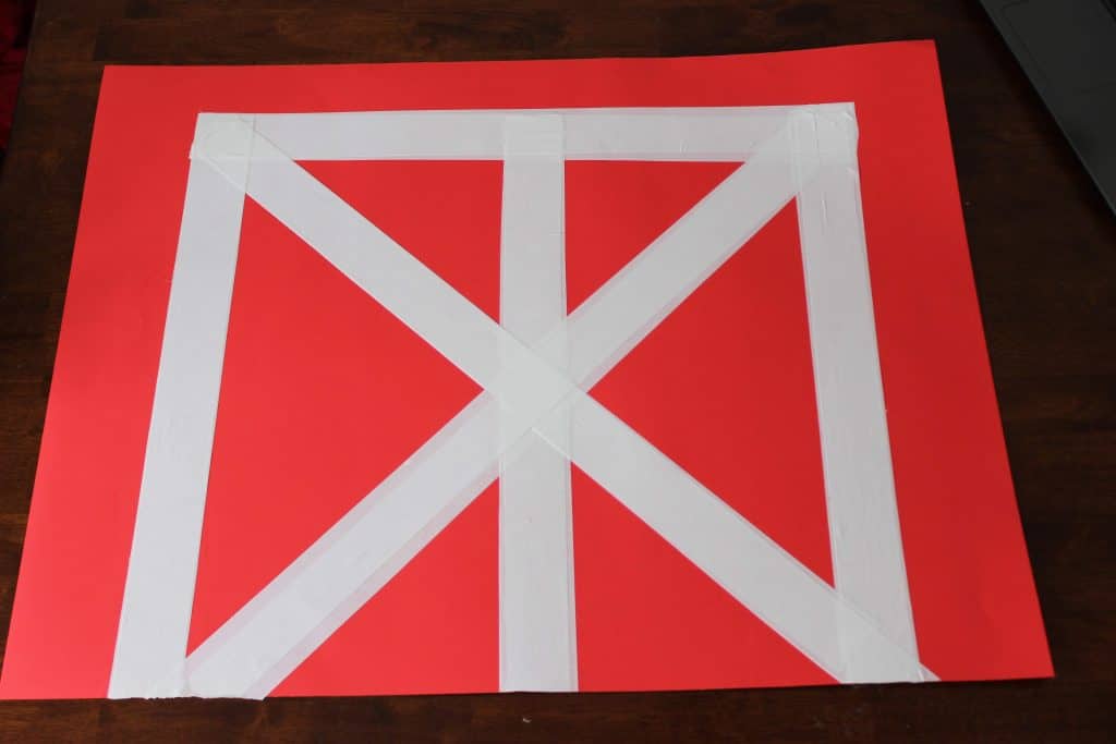 red posterboard with white duct tape outlining barn doors