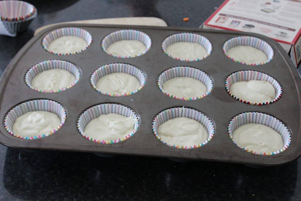 12 cup muffin tin filled with muffin cups and batter