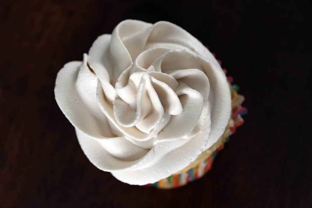 whipped cream piped onto cupcake