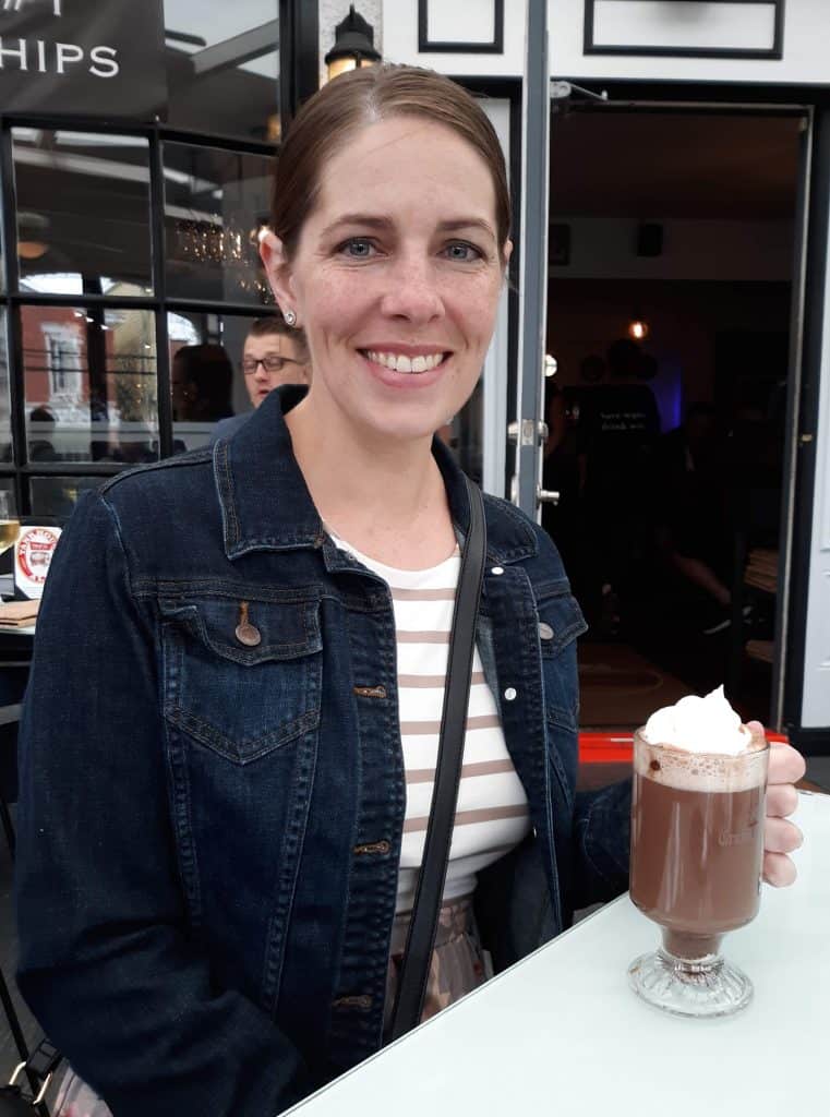 author sitting at table drinking hot chocolate