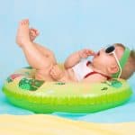 baby lounging in baby float wearing a swimsuit and sunglasses