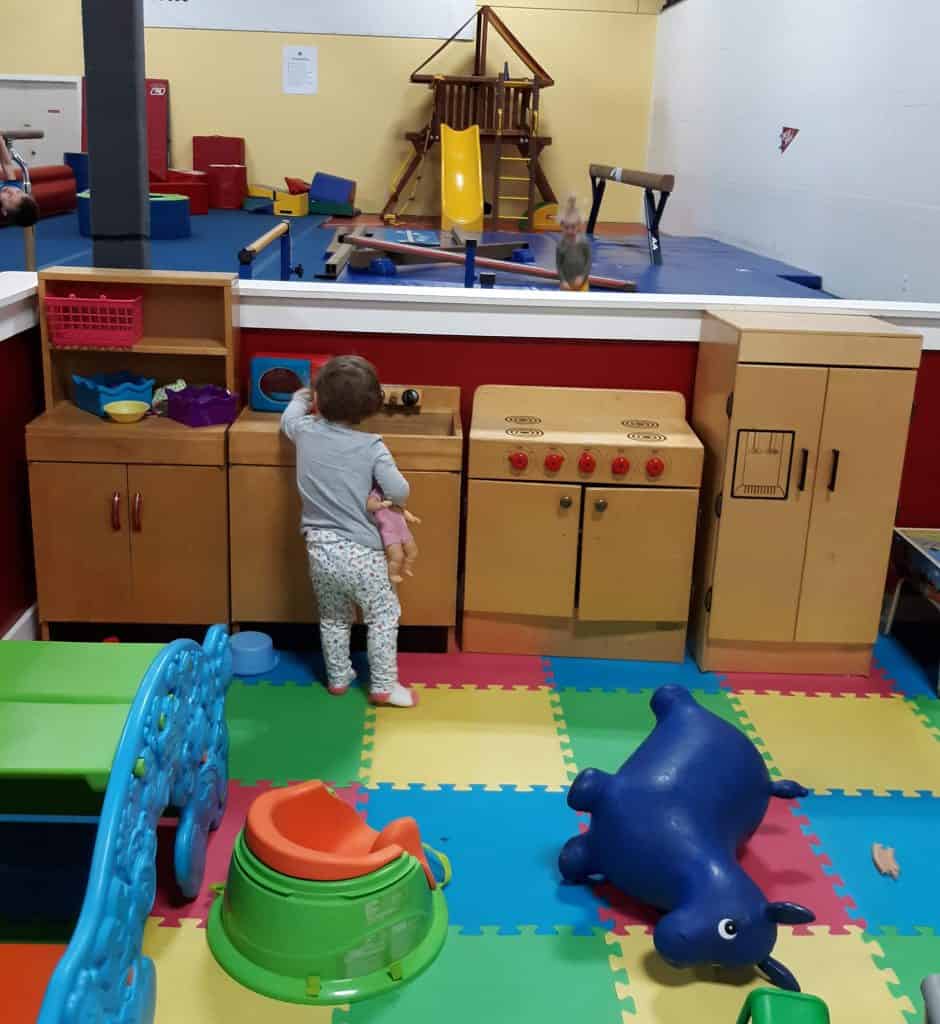 toddler playing in a kids' kitchen