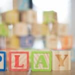 wooden baby blocks that spell out "PLAY"