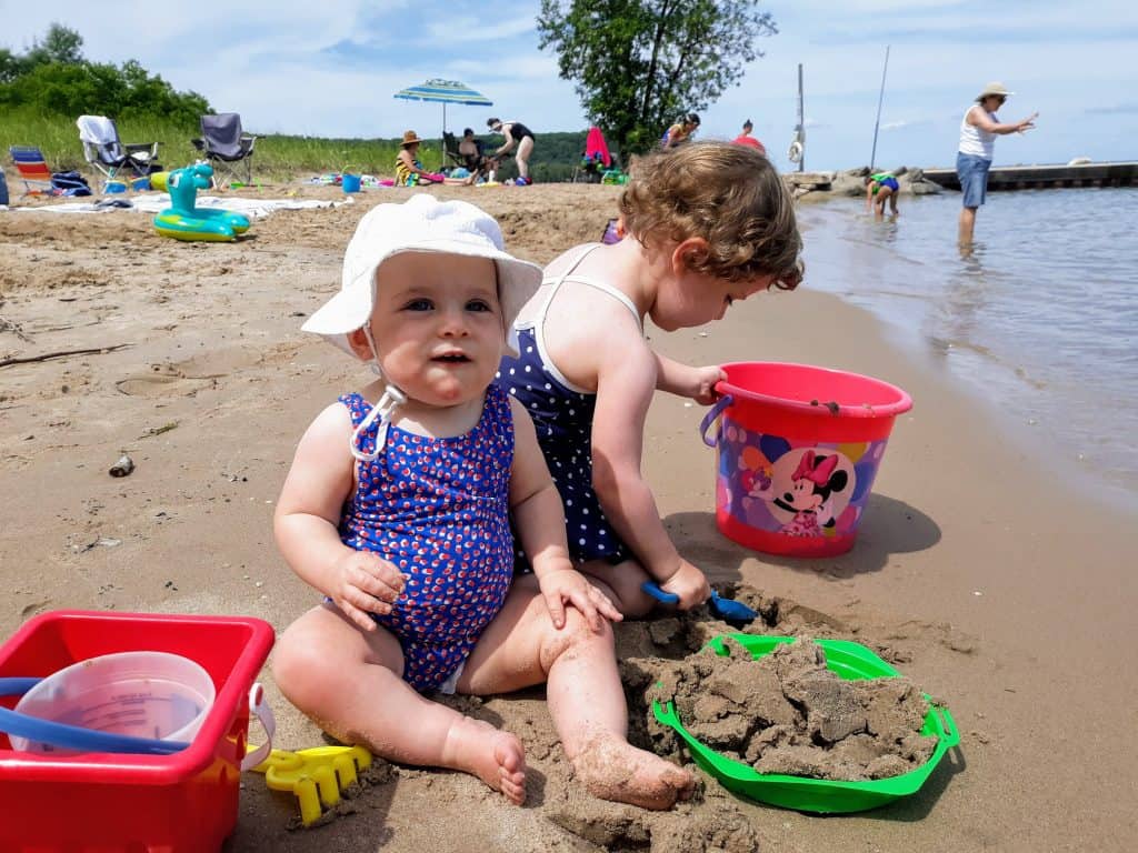 Baby and toddler playing in the sand