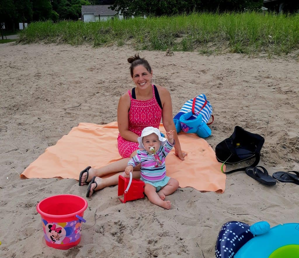 Mom and baby sitting on beach towel