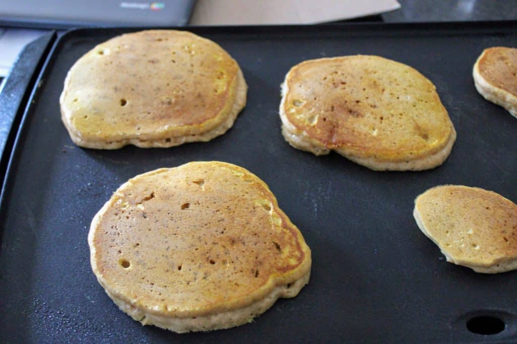 griddle with pumpkin pancakes on it