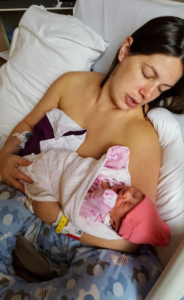 mom in hospital bed holding newborn