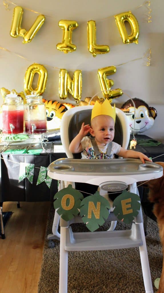 baby in high chair wearing gold crown