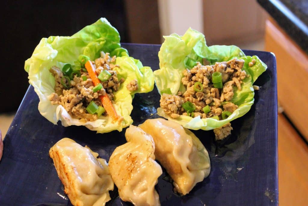 lettuce wraps and potstickers on blue plate