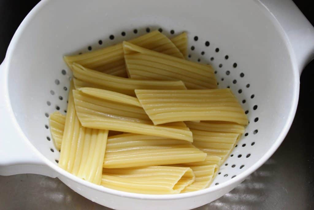 cooked manicotti noodles in a strainer