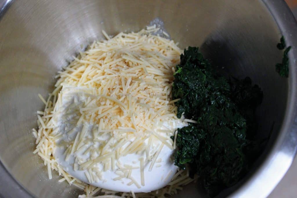 mixing bowl of ricotta, parmesan, and wilted spinach