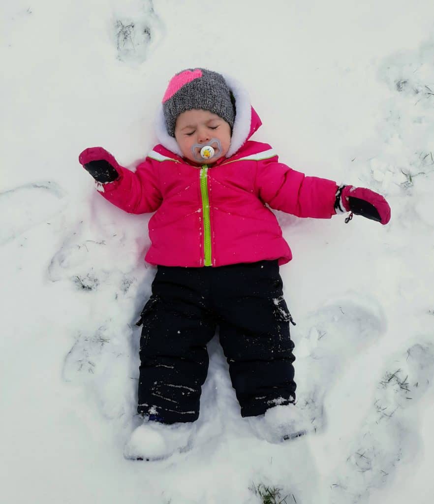 toddler laying down in snow