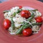 red bowl of gnocchi, green beans, and grape tomatoes