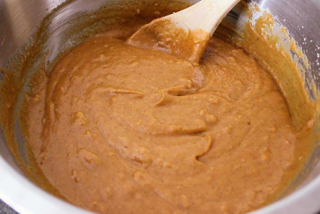 pumpkin caramel lava cake batter in mixing bowl with wooden spoon