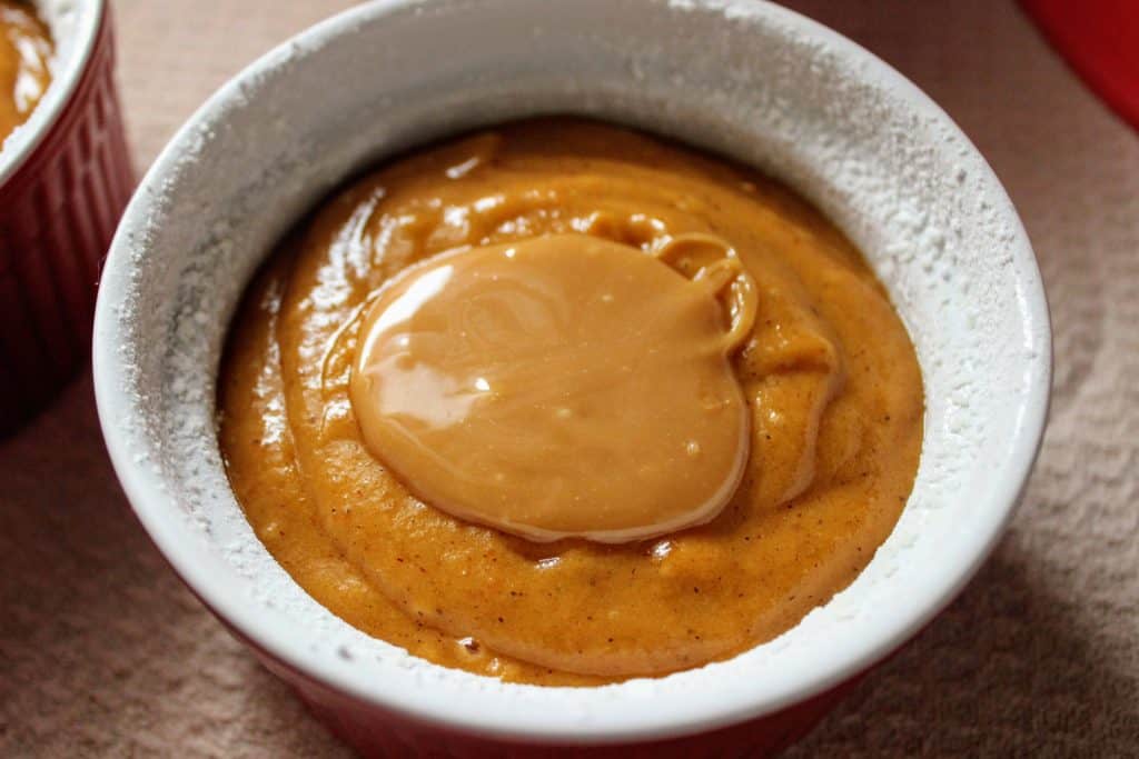 ramekin filled with cake batter and a tablespoon of caramel on top