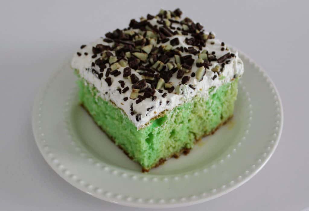 a square of Irish cream poke cake on a white dessert plate