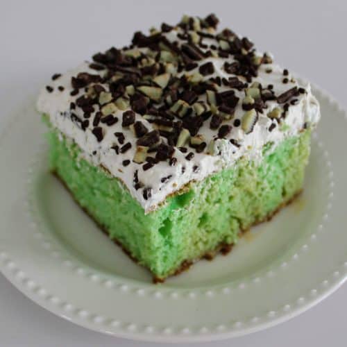 a square of Irish cream poke cake on a white dessert plate