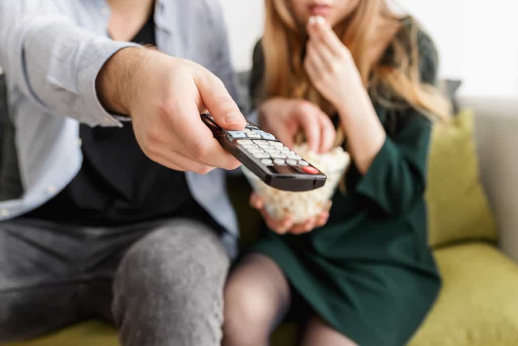 man holding remote control sitting next to woman