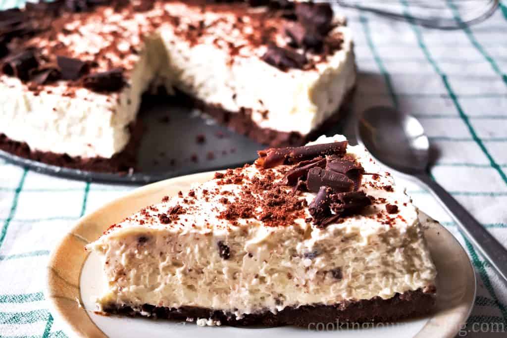 a slice of Baileys cheesecake with the remaining cheesecake in the background