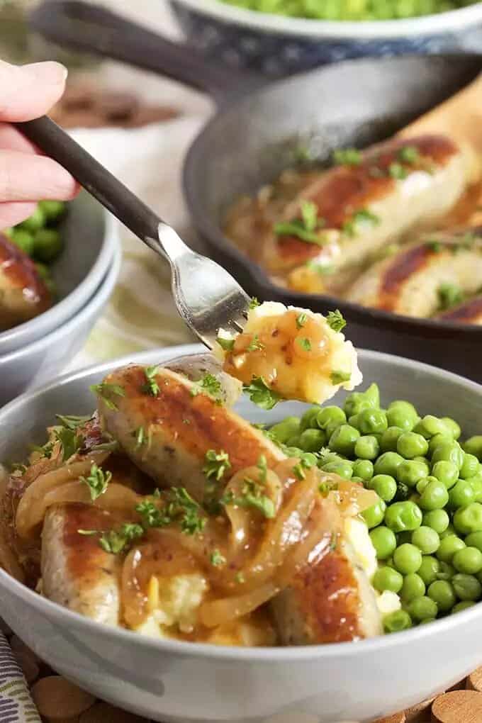 bangers and mash on a plate with peas