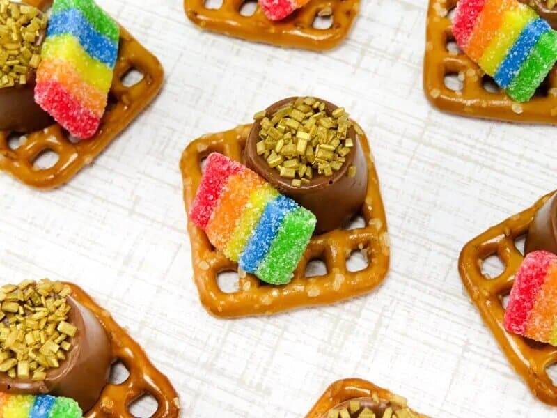 square pretzel topped with rainbow candy and rolo