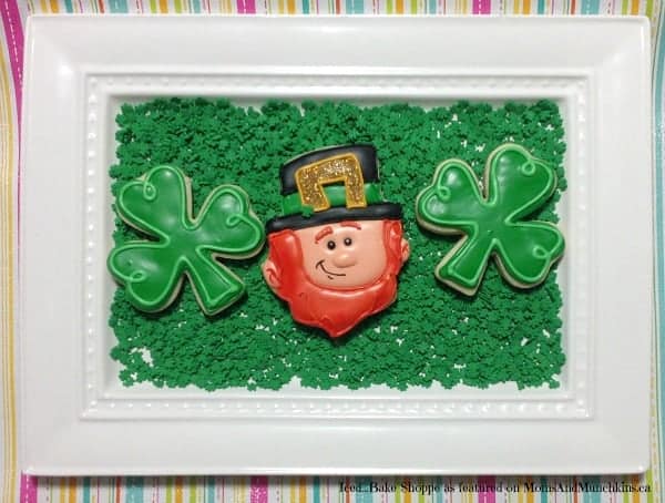 leprechaun cookie on a plate between two shamrock cookies