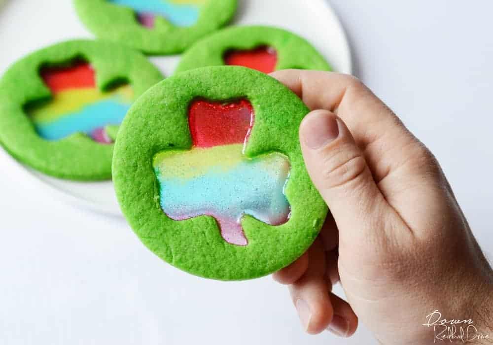 circular green cookie with a shamrock cutout featuring a rainbow middle