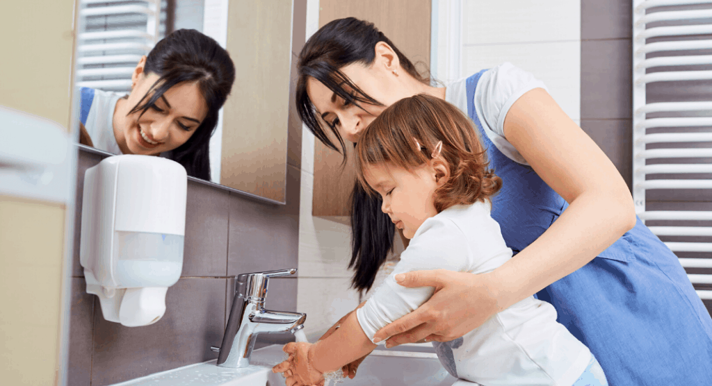 mom helping toddler wash hands