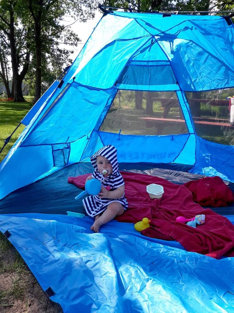 Baby sitting in sun tent