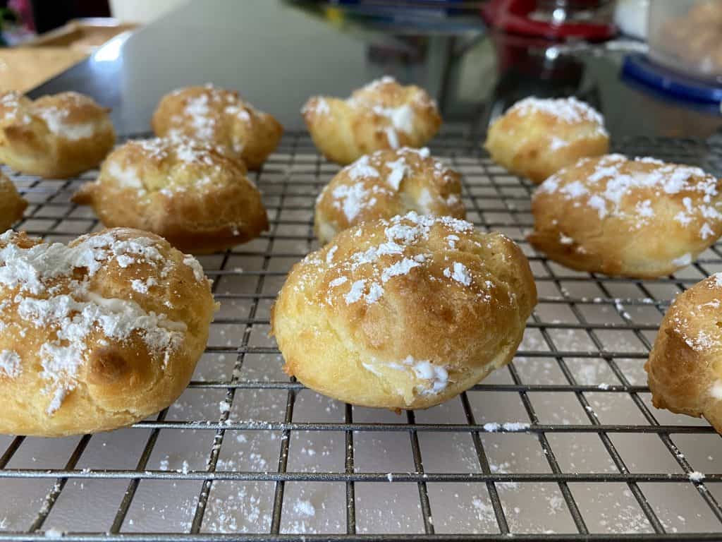 finished cream puffs on wire cooling rack