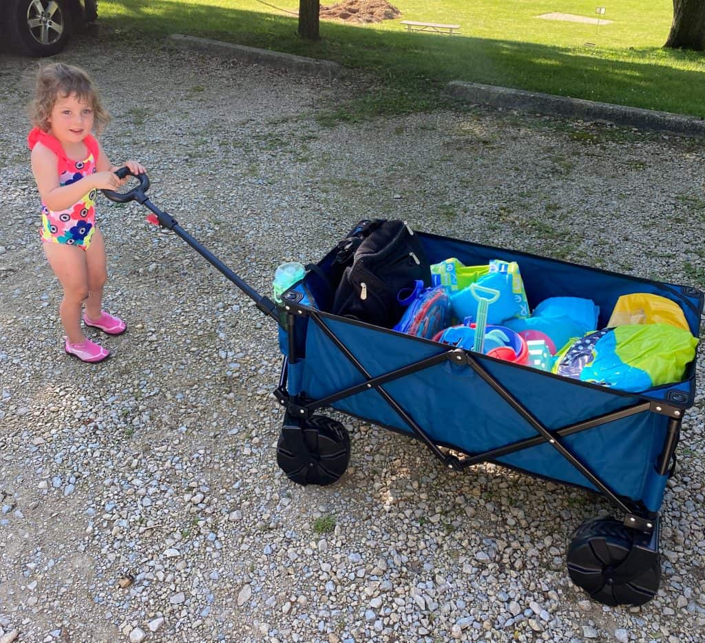 toddler pulling wagon full of beach essentials