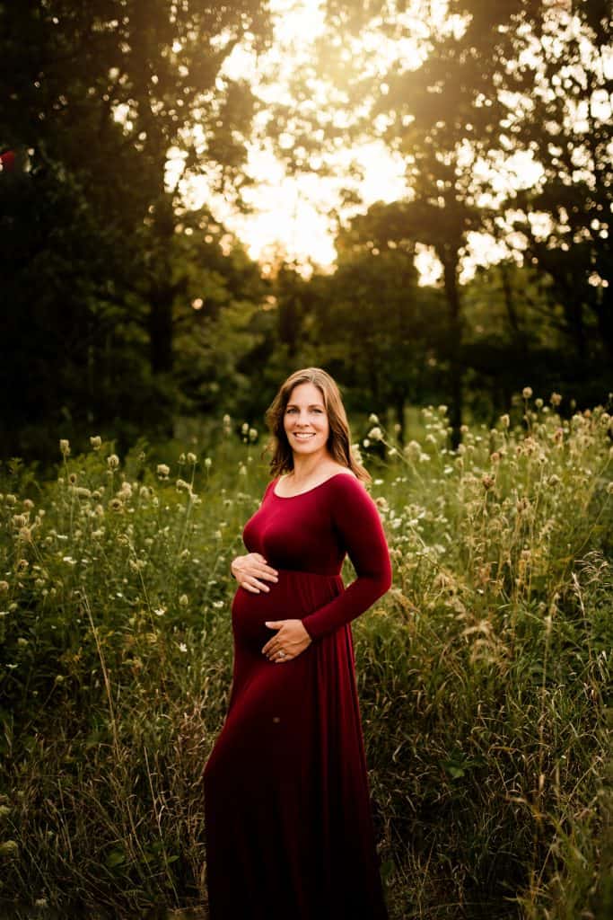 author posing for maternity photo in long dress