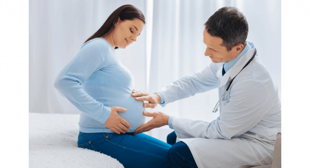 doctor touching pregnant woman's belly