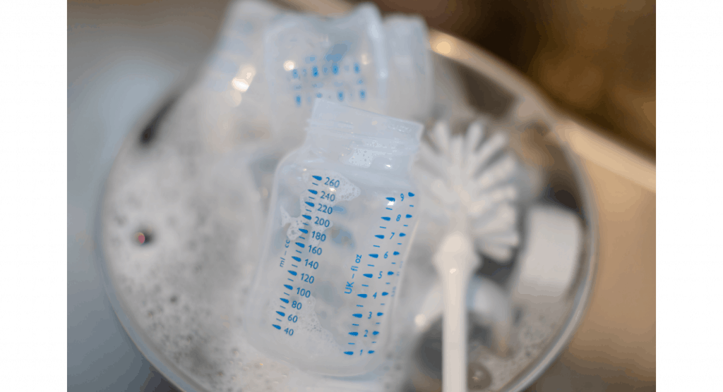 baby bottles in soapy water with bottle brush