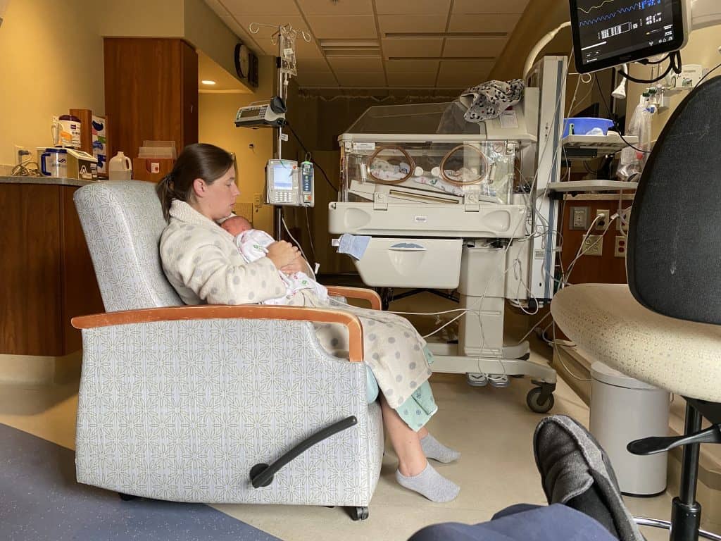 mom holding baby in NICU room