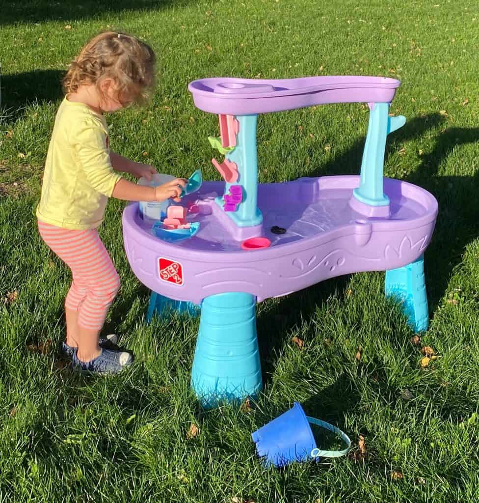 Child playing at a water table outside