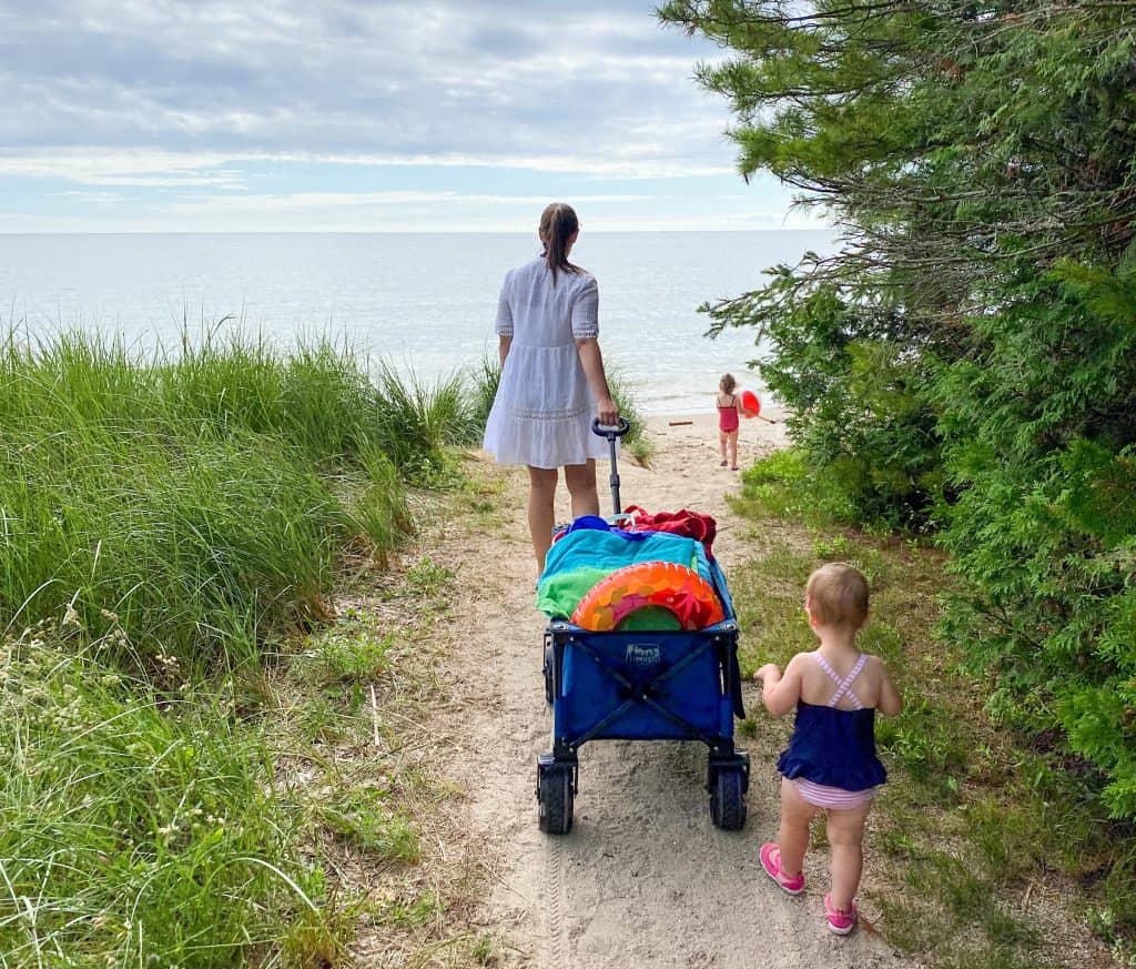 woman pulling wagon full of beach gear